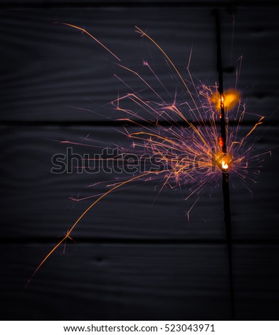 Beautiful burning Sparkler on wooden background, holiday concept