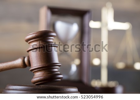 law theme, mallet of the judge, wooden desk, scales of justice, books, statue of justice and hourglass