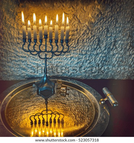 Menorah with the glitter lights of candles is traditional Jewish symbol for Hanukkah holiday. Selective focus. Low key image additionally toned for inspiration of retro style and ceremony evening