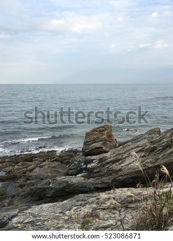 Rock eroded by waves on dark cloudy sky background
