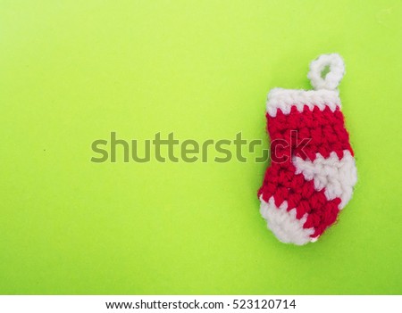 Empty red knitting Christmas sock on green background , copy space