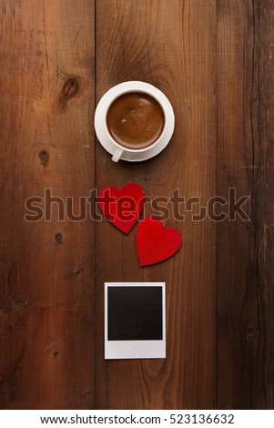 Cup of coffee, Retro Vintage empty Photo frames and red wooden hearts on old dark Background. Top view with copy space. Toned Love concept