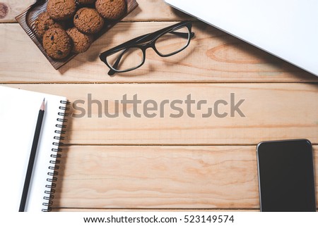 View from above of office supplies on a wooden working table background. Vintage retro picture style.