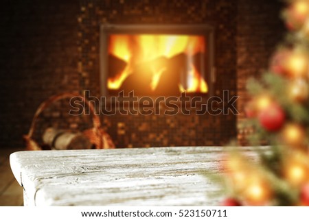 Wooden table of free space fireplace background and blurred xmas tree 