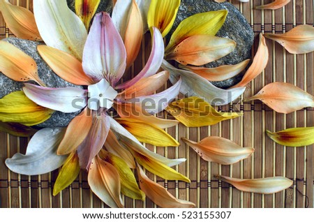 lily petals on a mat with wedding rings