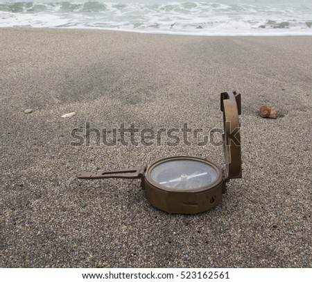 Beautiful background of the sea and travel, with a compass on the beach