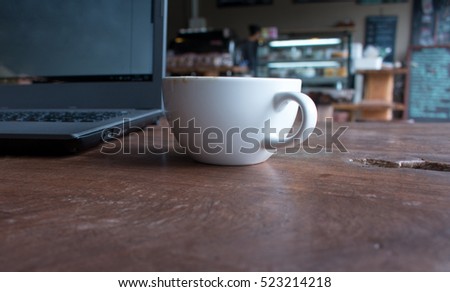 Close up of Cup of hot latte art coffee with laptop computer on wooden table, work with coffee concept picture foe business background.