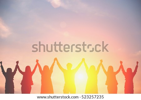 Silhouette of happy business team making high hands in sunset sky background for business teamwork concept.