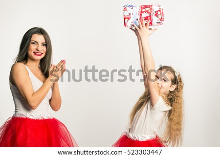 Mom and daughter in white shirts and the same tulle skirts. Congratulates Mom daughter with Christmas or New Year. Joy. White background. Mock up. Human. New Year. Christmas.