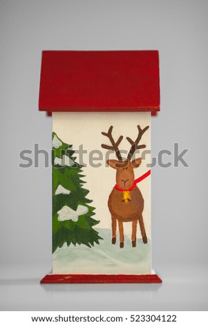 Traditional Christmas decorations and toys. Wooden house with Christmas trees painted on it