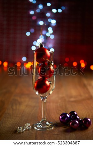 Glass of champagne with Christmas tree decorations and bokeh. Selective focus.