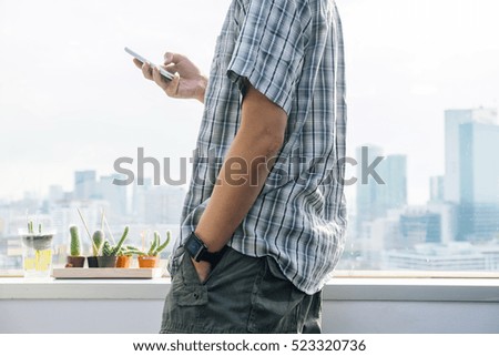 Relaxed young man in casual clothes typing message on smartphone, people and innovation technology conception