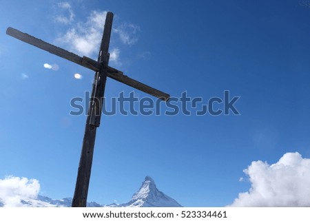 wooden cross over a blue sky and mountain Matterhorn, Switzerland, belief and hope, dangerous alpinisme