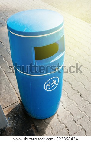 Blue bin made from plastic seen from above during a sunny day