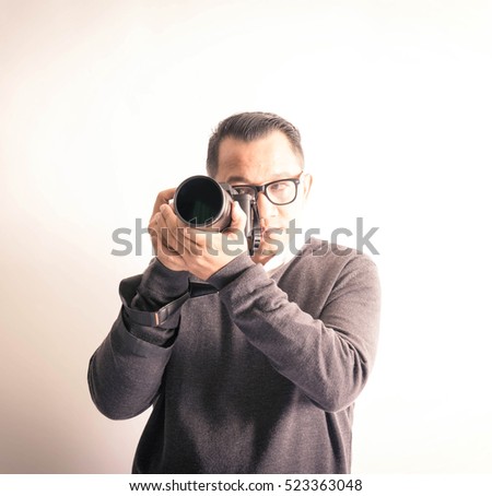 An asian man with camera in various actions.