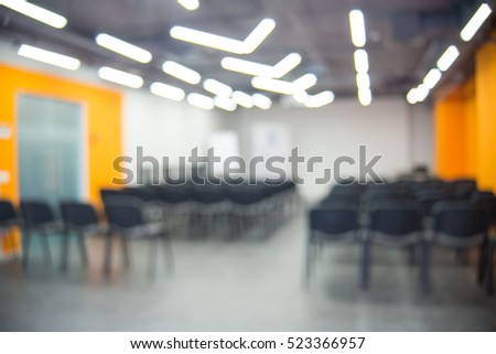 Blurred image of audience hall or auditorium with screen, blur background