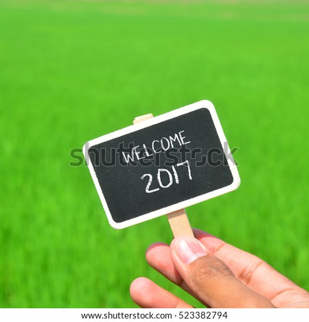 Selective focus of chalk board with WELCOME 2017 text. Nature green background. 