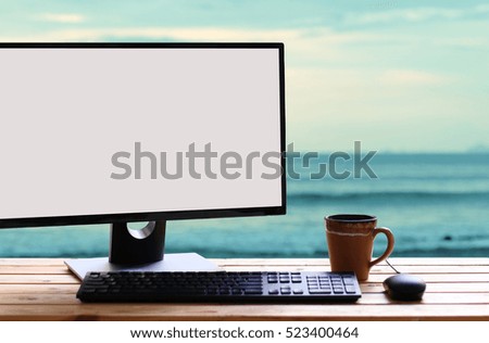 Coffee cup and Computer PC on wooden table background sea morning.copy space.concept of time relax.