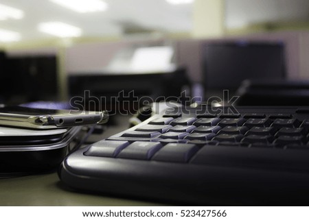 Close up black keyboard was located in the office with blurred office Interior on background.