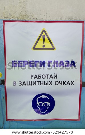 Warning poster.The inscription on the poster "take Care of your eyes.Work in protective glasses"