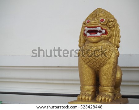 Free standing lion sculpture on the entrance to Thai temple