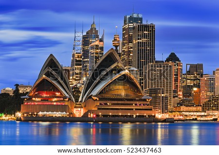 Waterfront cityline of Sydney city downtown at sunrise with bright illumination of modern architectural landmarks Royalty-Free Stock Photo #523437463