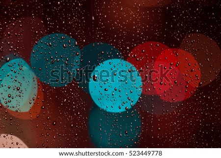 Rain drops on window with street bokeh lights, colorful street lights
