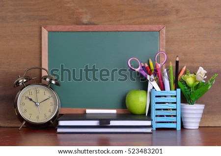 Back to school concept with books and alarm clock with chalkboard