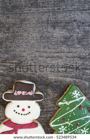 Snowman and christmas tree cookies on grunge wooden table background with copy space for text, Greeting card style for merry xmas and happy new year