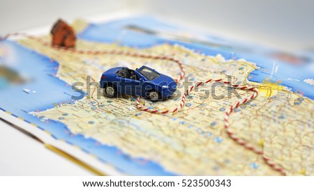 Abstract idea of rent a car. Small car on map. Royalty-Free Stock Photo #523500343