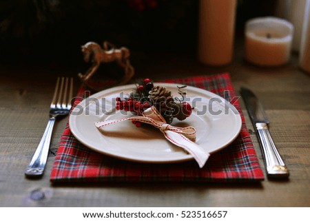 Christmas place setting and decorations on wooden table