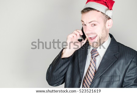 businessman in a Christmas hat and mobile