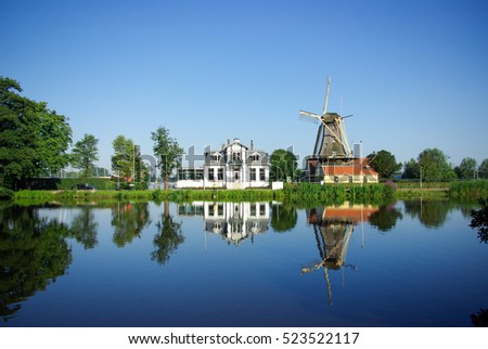 Windmill reflecting in a lake, Holland  Royalty-Free Stock Photo #523522117