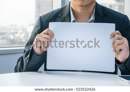 Businessman holding white paper in the office