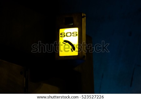 Emergency SOS telephone point in tunnel bright light yellow icon sign