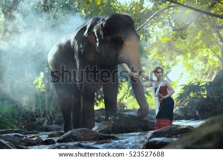 Beautiful Asian Woman wear thai dress with her elephant