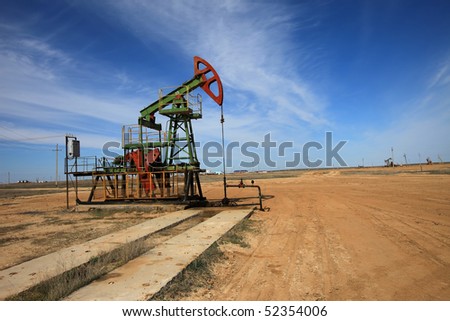 An oil pump jack on blue sky.