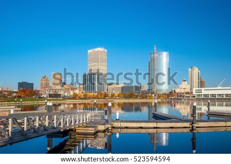 Milwaukee skyline  with city reflection in lake Michigan and harbor pier.