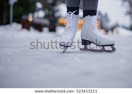 Legs of ice skater with start sign on the ice rink, view from above