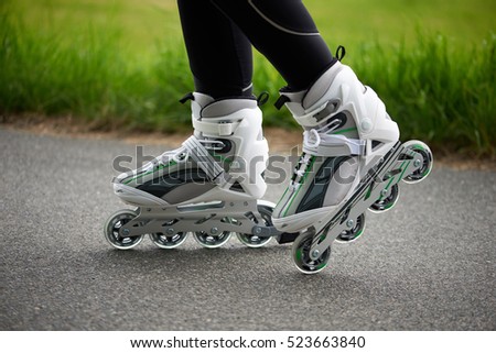 Close-up of female legs riding roller skates.