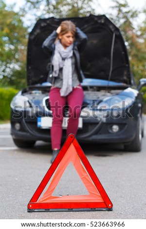 Picture of a frustrated young woman stuck on the road because of an accident