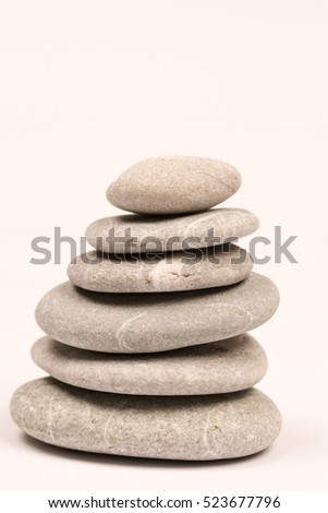 Balanced grey stones over white background with copy space
