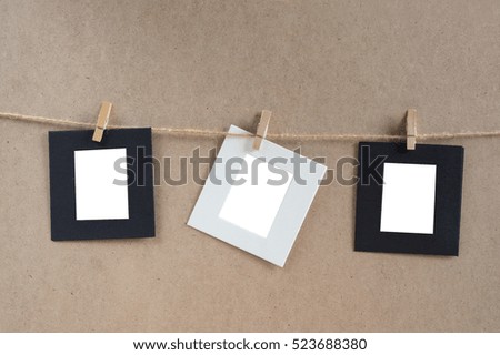 Paper cards hang on rope by wooden clip.