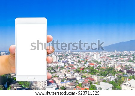 Man use mobile phone, blur image of bird's-eye view of buildings in the capital as background.