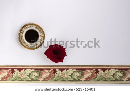 Cup of coffee with red rose and roll of wallpaper to decorate the house, white background, natural light, view from above