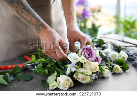Male florist making bouquet at flower shop