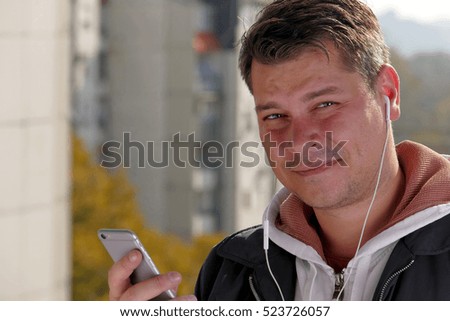 Man using smartphone on balcony during the sunny day