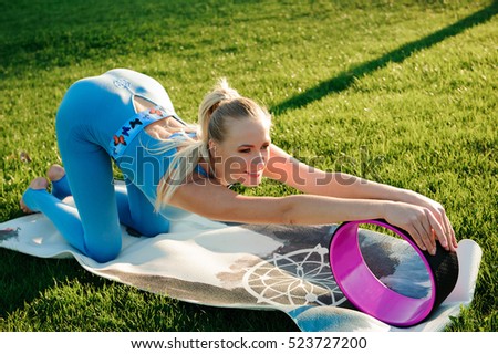 Young beautiful woman doing yoga exercises in park