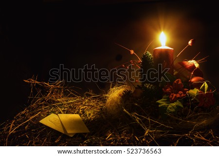Christmas decoration with wafers and candle. Black background. Warm tone.