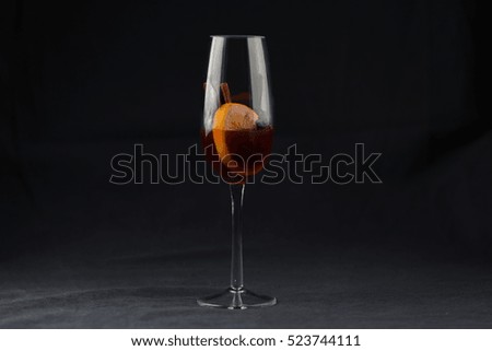 Red wine glass isolated on a black background. One glass of red wine isolated on black background. Christmas mulled wine with cinnamon, star anise and orange. Silhouette glass. Celebrate event. 